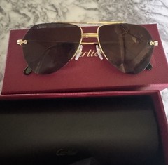 Authentic Cartier aviator-style sunglasses with gold-tone frame and dark lenses.